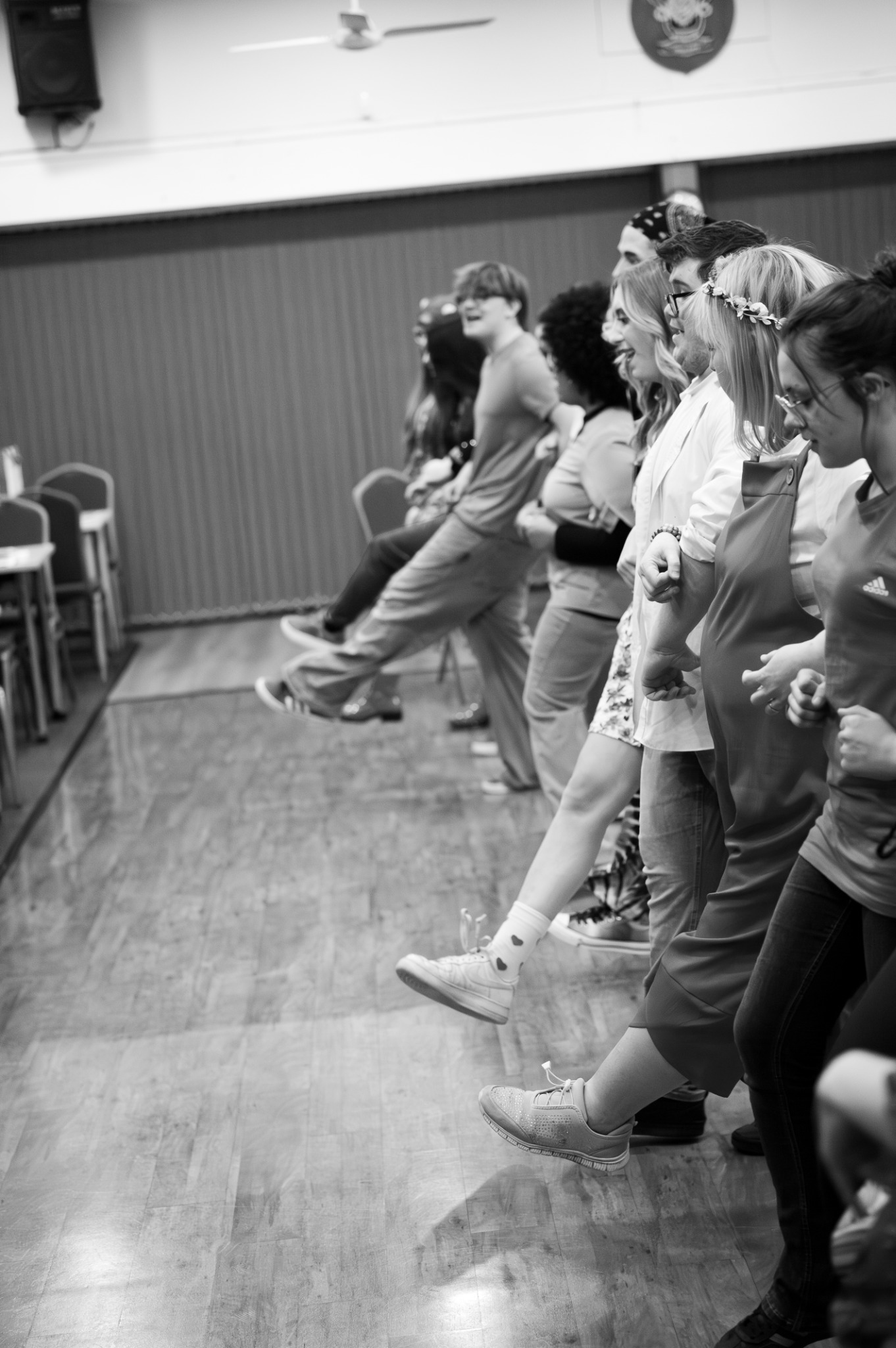 A black and white photograph of the company rehearsing a kick line
