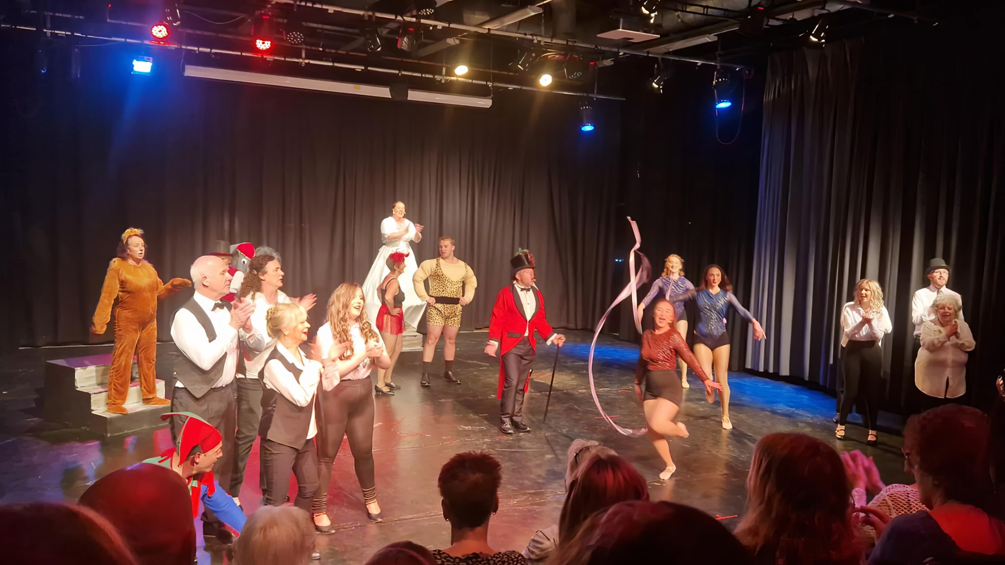 The company performing together under stage lights