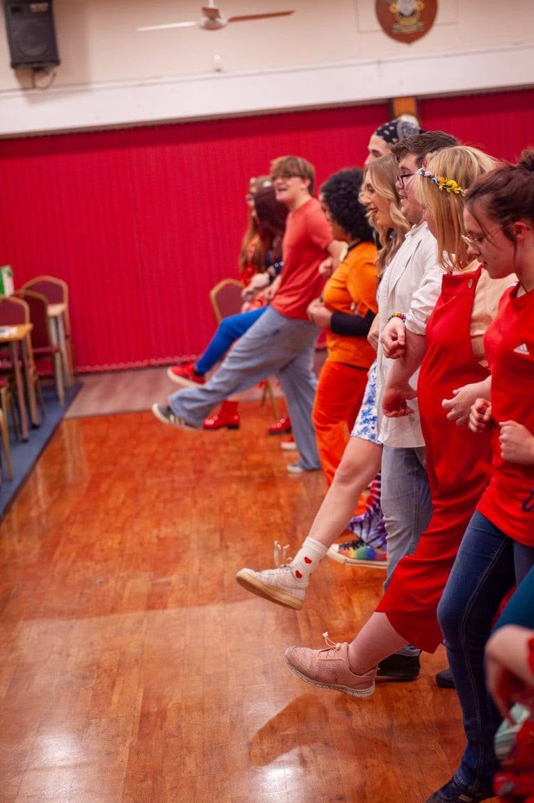 Company members practising a kick line in rehearsal