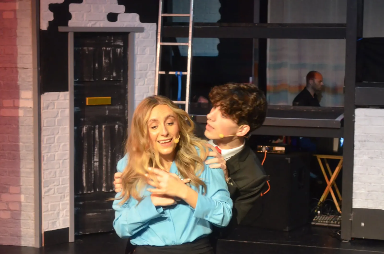 Two performers embracing in a scene