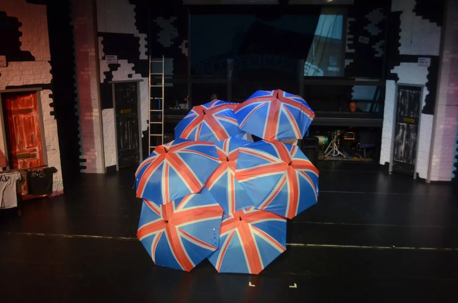 Union Jack umbrellas arranged on a theatre stage